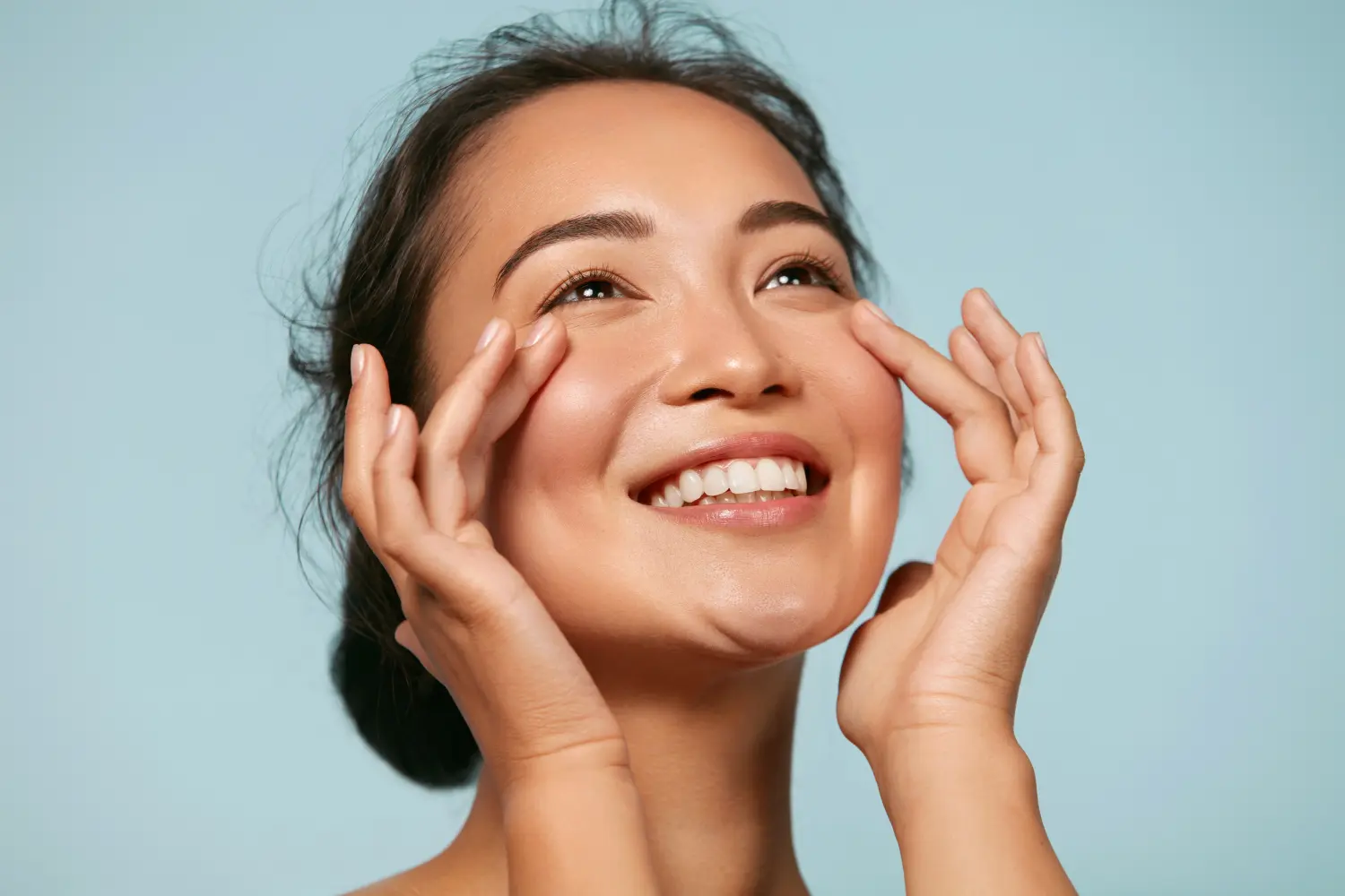 Hautpflege. Frau mit Schönheit Gesicht berühren gesunde Gesichtshaut Porträt. Schöne lächelnde asiatische Mädchen Modell mit natürlichen Make-up berühren glühende hydratisierte Haut